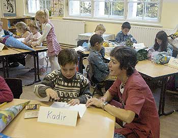 Schulkinder mit Lehrerin in Klasssenraum