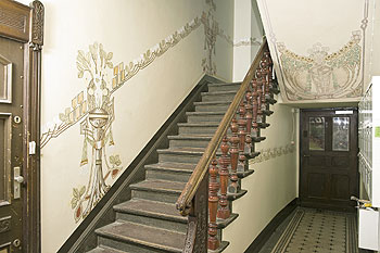 Treppe in einem restaurierten Altbau-Treppenhaus mit kunstvollen Malereien und Ornamenten