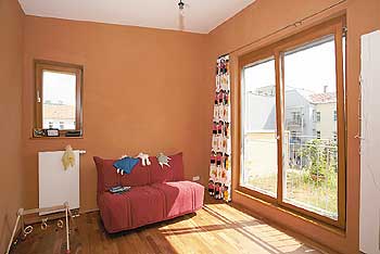 Ein in braunen und roten Tönen gestaltetes Zimmer mit großem Fenster nach außen