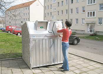 Eine junge Frau entsorgt ihren Müll in einer Müllschleuse
