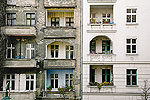 Unsaniertes Haus mit Fassadensch&auml;den neben einem sanierten Altbau