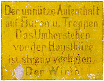 Schild mit der Inschrift: Der unnütze Aufenthalt auf Fluren u. Treppen, Das Herumstehen vor der Hausthüre ist streng verboten. Der Wirth