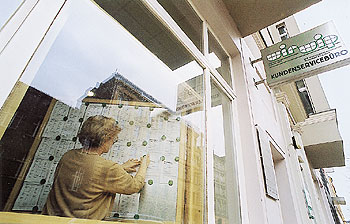 Schaufenster mit Aushängen des Büros der Wohnungsbaugesellschaft WIR