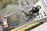 Feuerwehrmann auf einer ausgefahrenen Leiter an einer Hochhausfassade