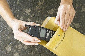 Mobilfunktelefon wird in einen Briefumschlag gesteckt