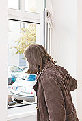 Wohnungsinteressentin schaut aus dem Fenster der neuen Wohnung