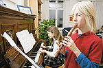 Zwei Jugendliche spielen in einer Mietwohnung Klavier und Blockfl&ouml;te