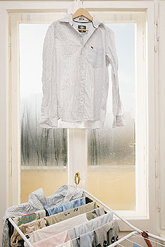 Wäschetrocknung in der Wohnung, Hemd trocknet vor geschlossenem Fenster