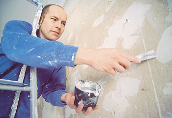 Handwerker beim Verspachteln einer Wand