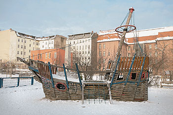 Spielplatz mit Holzschiff und sanierte Gebäude an 'Marie'