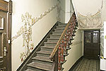 Treppe in einem restaurierten Altbau-Treppenhaus mit kunstvollen Malereien und Ornamenten