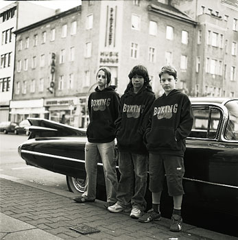Drei Jugendliche vor einem Straßenkreuzer in der Neuköllner Karl-Marx-Straße