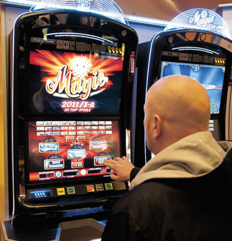 Glatzköpfiger Spieler an einem Glücksspiel-Automaten