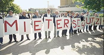 Protestierende Menschen, die Schilder mit den Buchstaben 'Mieterschutz' tragen