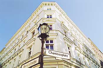 Fassade eines Altbaus mit Straßenschildern 'Chamissoplatz' und 'Arndtstraße'