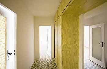 Blick in einen schmalen dunklen Flur, von dem mehrere Türen abgehen