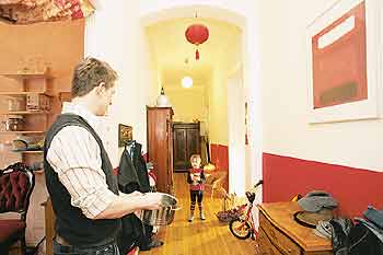 Ein Kind steht im Flur und schaut seinem Vater bei Hausarbeiten zu