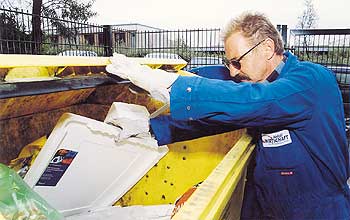 Ein Mann sortiert Müll in einer gelben Wertstofftonne