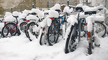 Fahrräder stehen im Hinterhof im Schnee und sind der Witterung ausgeliefert