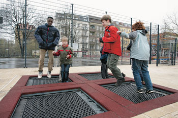 Kinder auf einem Spielplatz springen auf Sprungmatten
