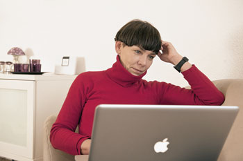Eine Frau surft zu Hause auf ihrem Laptop im Internet