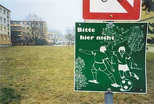 Grünfläche mit einem Schild mit der Aufschrift: Bitte hier nicht Fußballspielen