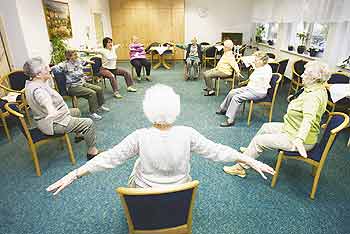 Seniorengruppe übt gemeinschaftlich Armbewegungen im Sitzen