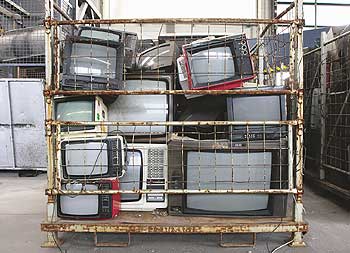Alte Fernsehgeräte in einem Gitter-Container bei der Stadtreinigung