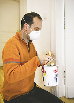 Mann mit Gesichtsmaske streicht Tür