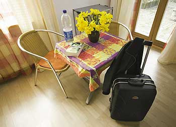 Zimmer mit Tisch und Stühlen, und einem Reisekoffer