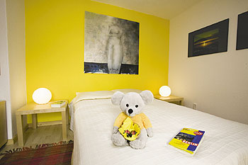 Zimmer mit Bett und Kuschel-Teddy, Stadtplan, Nachttischen und Bildern an den Wänden