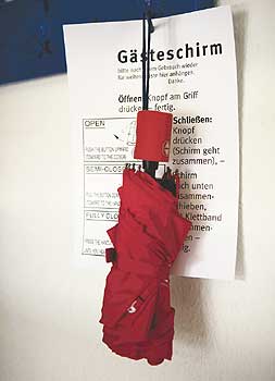 Angehängter Regenschirm mit Infozettel zur Benutzung für Gäste