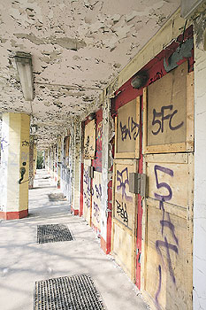 Wohnnutzung beendet: Abbröckelnder Putz und Graffitis an der Wand in der Herzbergstraße in Lichtenberg