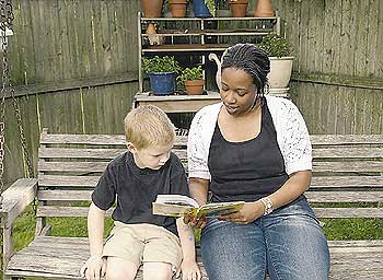 Ein Au-pair-Mädchen liest einem kleinen Jungen aus einem Buch vor