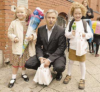 Der Regierende Bürgermeister Klaus Wowereit zwischen zwei Mädchen mit Schultüten bei der Einschulung