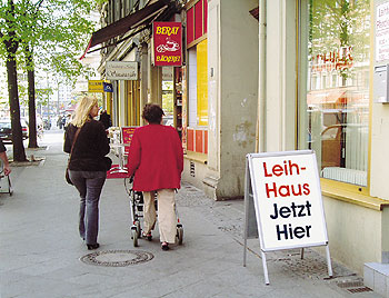 Ein Schild mit der Aufschrift 'Leihhaus jetzt hier' in einer Straße in Mitte
