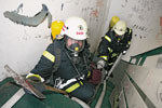 Feuerwehrleute mit Schläuchen in einem Treppenhaus