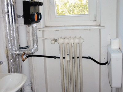 Rohrleitungen laufen durch ein Altbau-Badezimmer