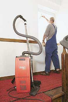 Staubsauger in einem Treppenhaus und jemand, der die Fenster putzt