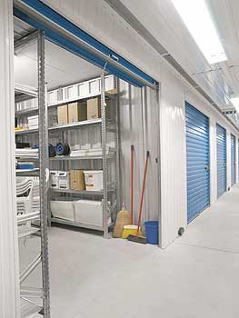 Ein offener Lagerraum mit Regalen neben Lagerräumen hinter Rollgittern
