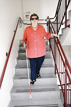 Sehbehinderte Mieterin auf einer Treppe mit speziellem Leitsystem
