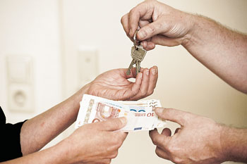 Vier Hände bei der Übergabe von Schlüsseln gegen Geld