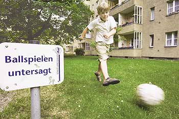 Ball spielendes Kind auf dem Rasen einer Wohnanlage - umstrittener Mietminderungsgrund