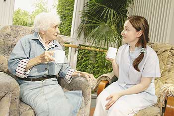 Seniorin trinkt Kaffee mit Betreuerin
