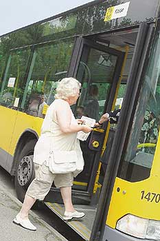 Seniorin steigt in einen Bus