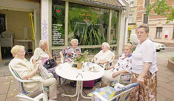 Seniorinnen beim Kaffeekränzchen vor einem Straßencafé