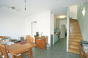 Wohnraum mit Esstisch, eine Treppe führt in das Obergeschoss