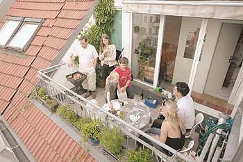 Familie beim Grillen auf dem Balkon