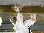Ein Asbestsanierer in Schutzanzug bei der Arbeit