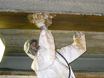 Ein Asbestsanierer in Schutzanzug bei der Arbeit